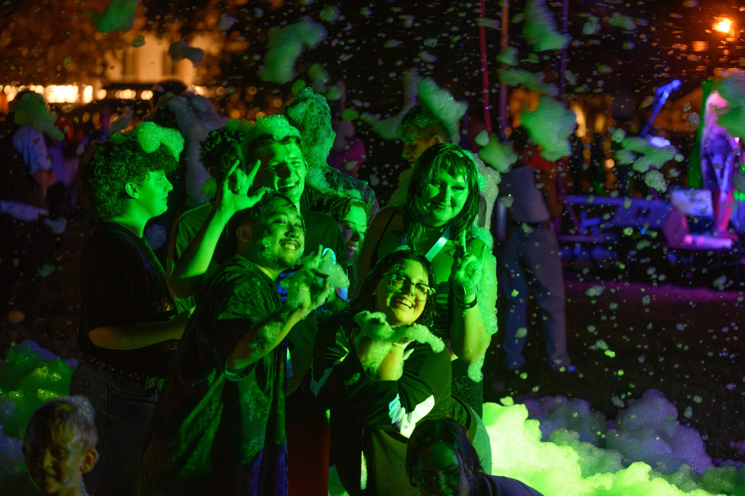 Group of college students pose in a bubble pit.